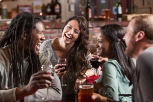 Multiracial group of friends drinking at restaurant bar