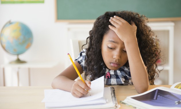 Frustrated mixed race student working in classroom