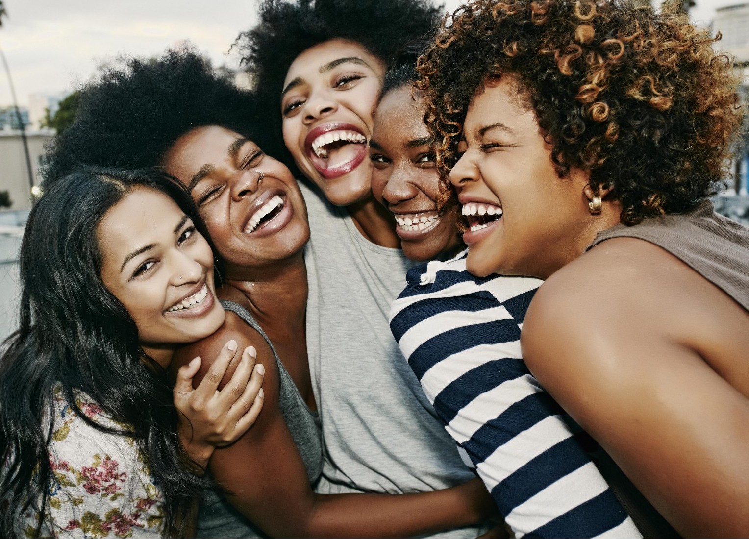 Women laughing together on urban rooftop