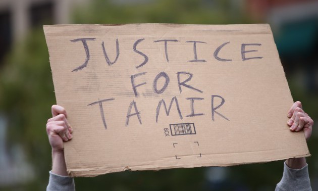 Justice for Tamir sign held aloft. Stop Mass Incarcerations...