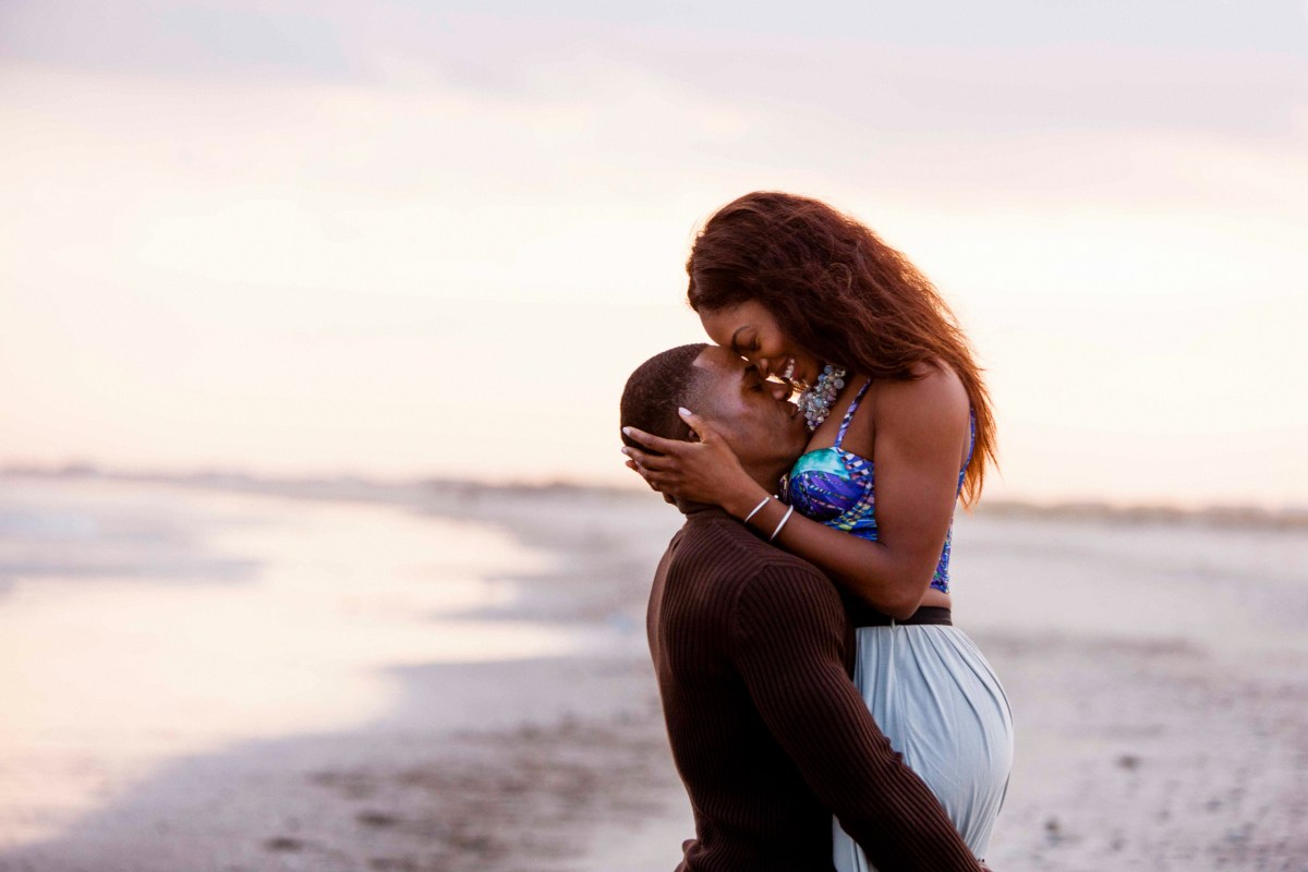 Couple on beach, hugging, face to face