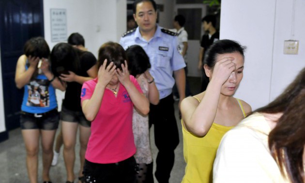 Chinese police lead away a group of youn