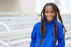 Mixed race boy smiling on bleachers