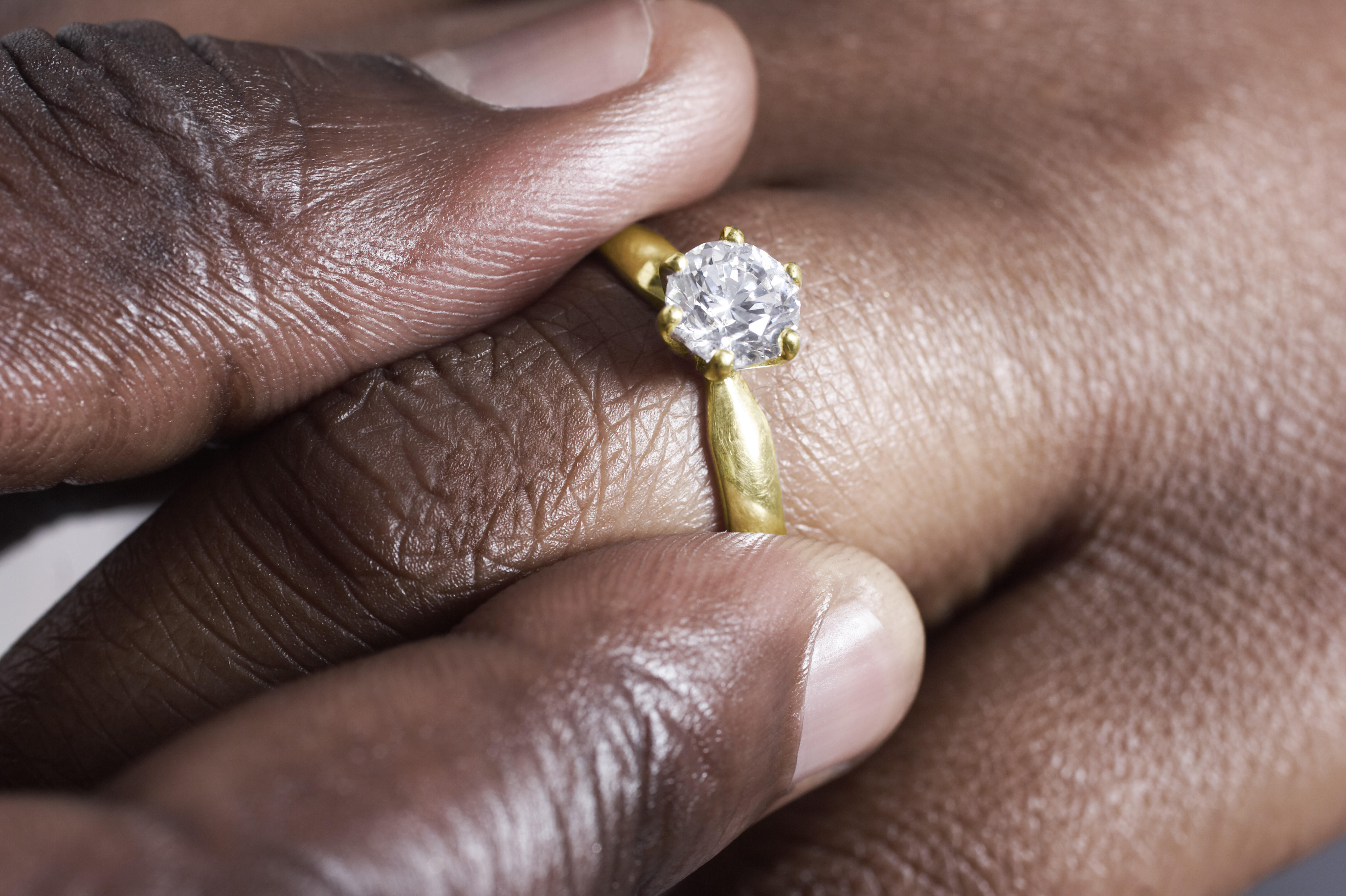 Man putting wedding ring on woman.