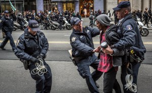 Policemen arrest a protester at the Anti-Trump rally.