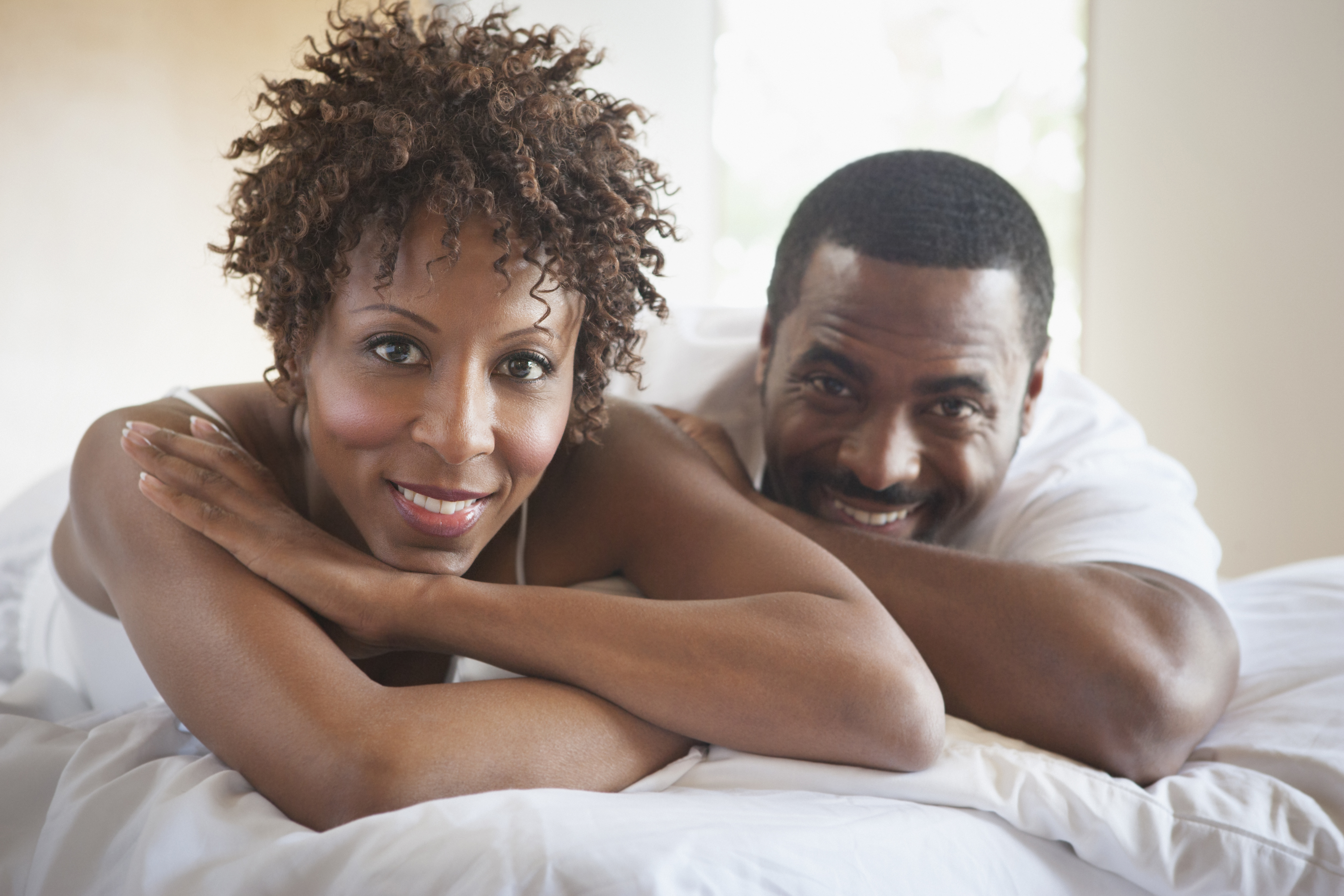 African American couple relaxing in bed