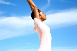 Woman Doing Yoga On Sand At Beach