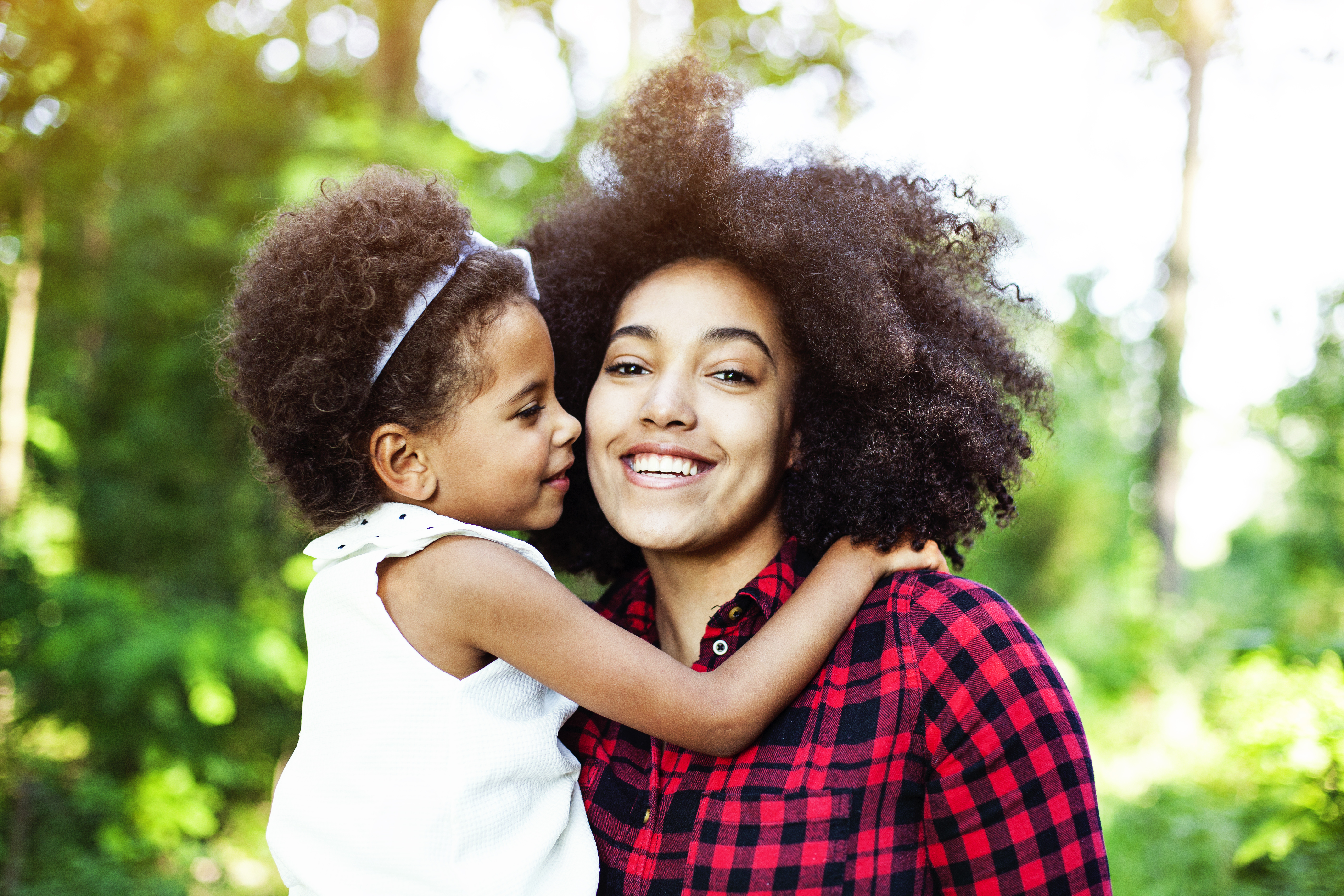 Mother and daughter hugging outdoors