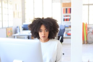 Young african woman sitting at workplace
