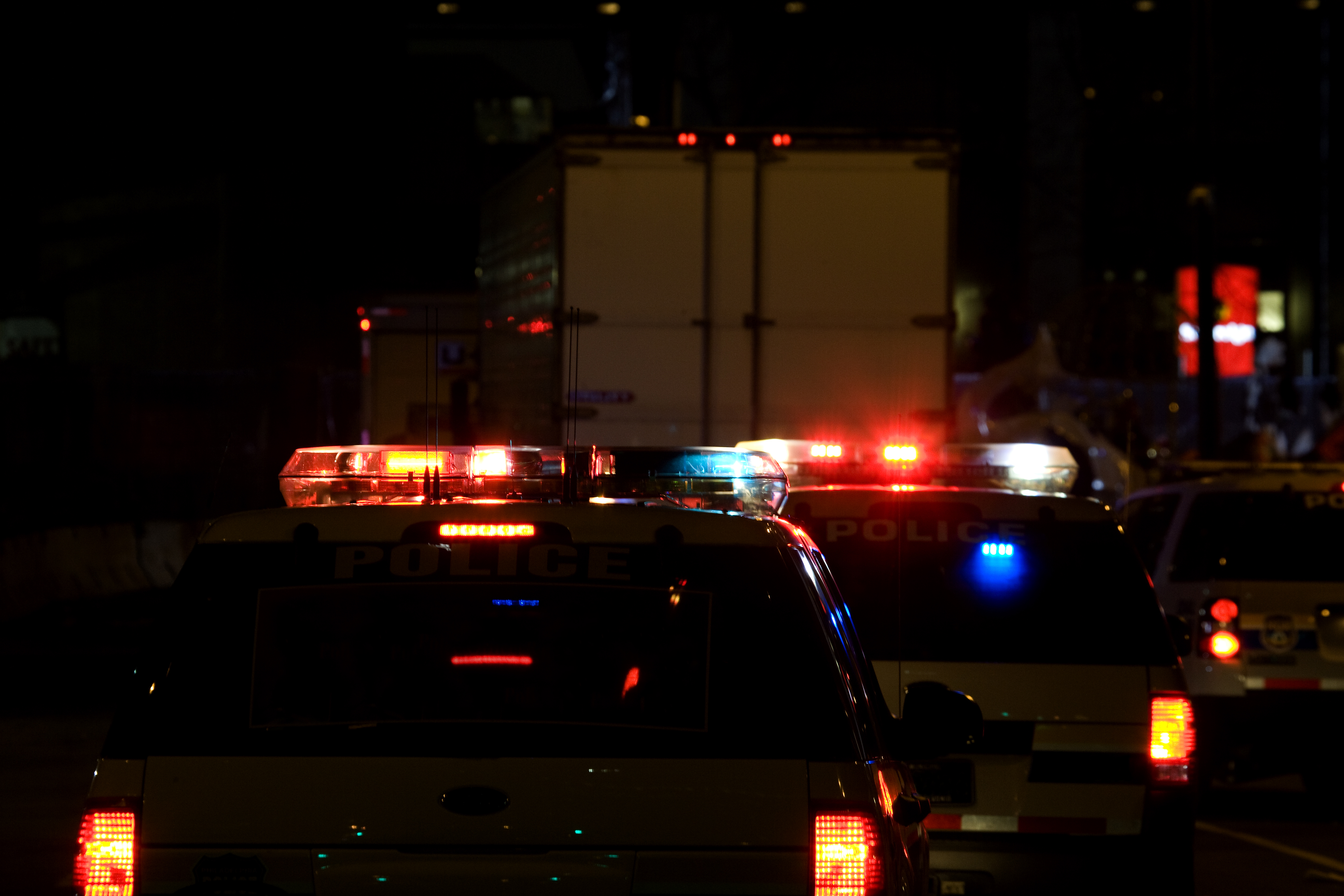 Police cars drive with their lights flashing.