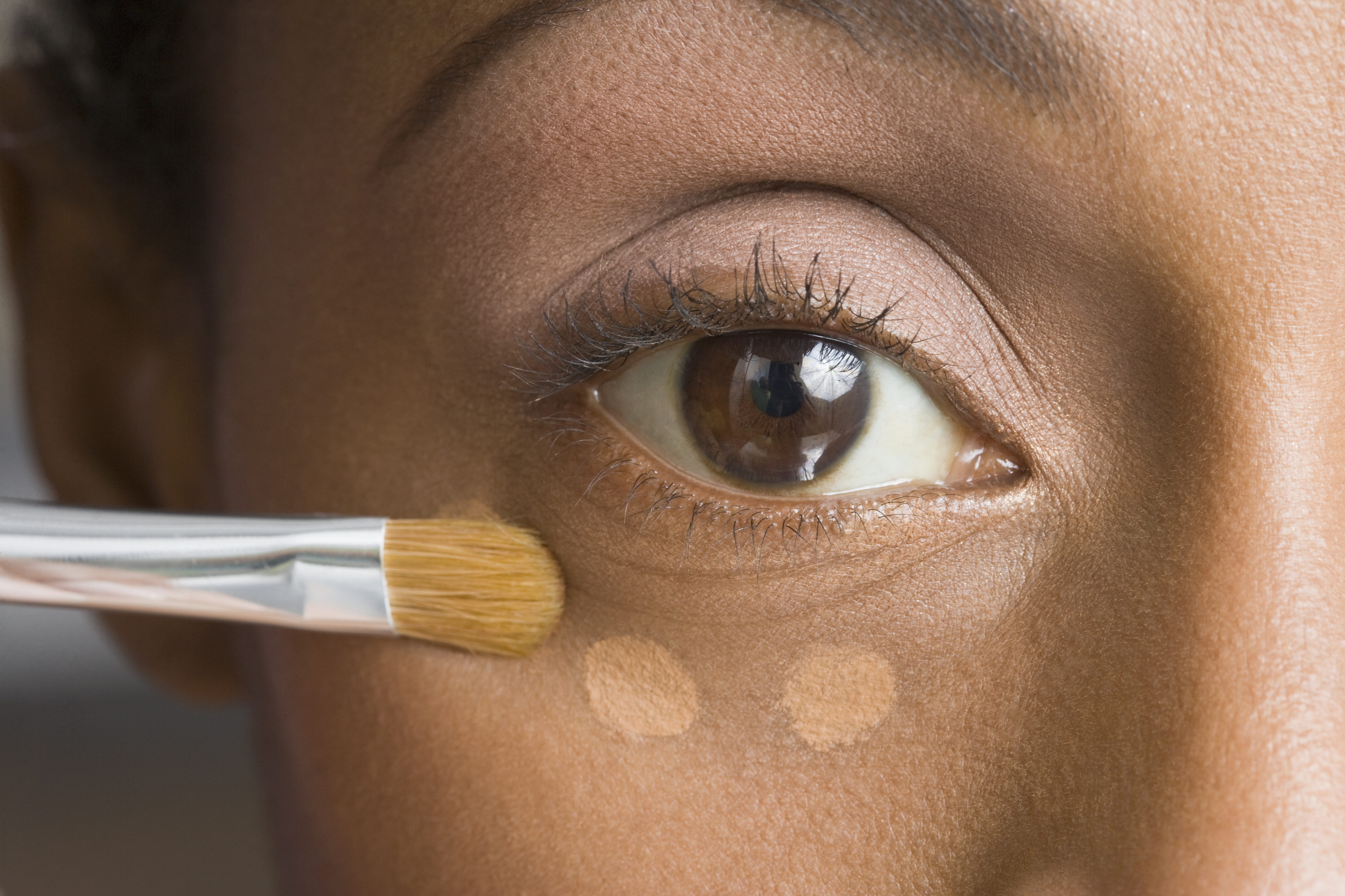 African American woman applying makeup