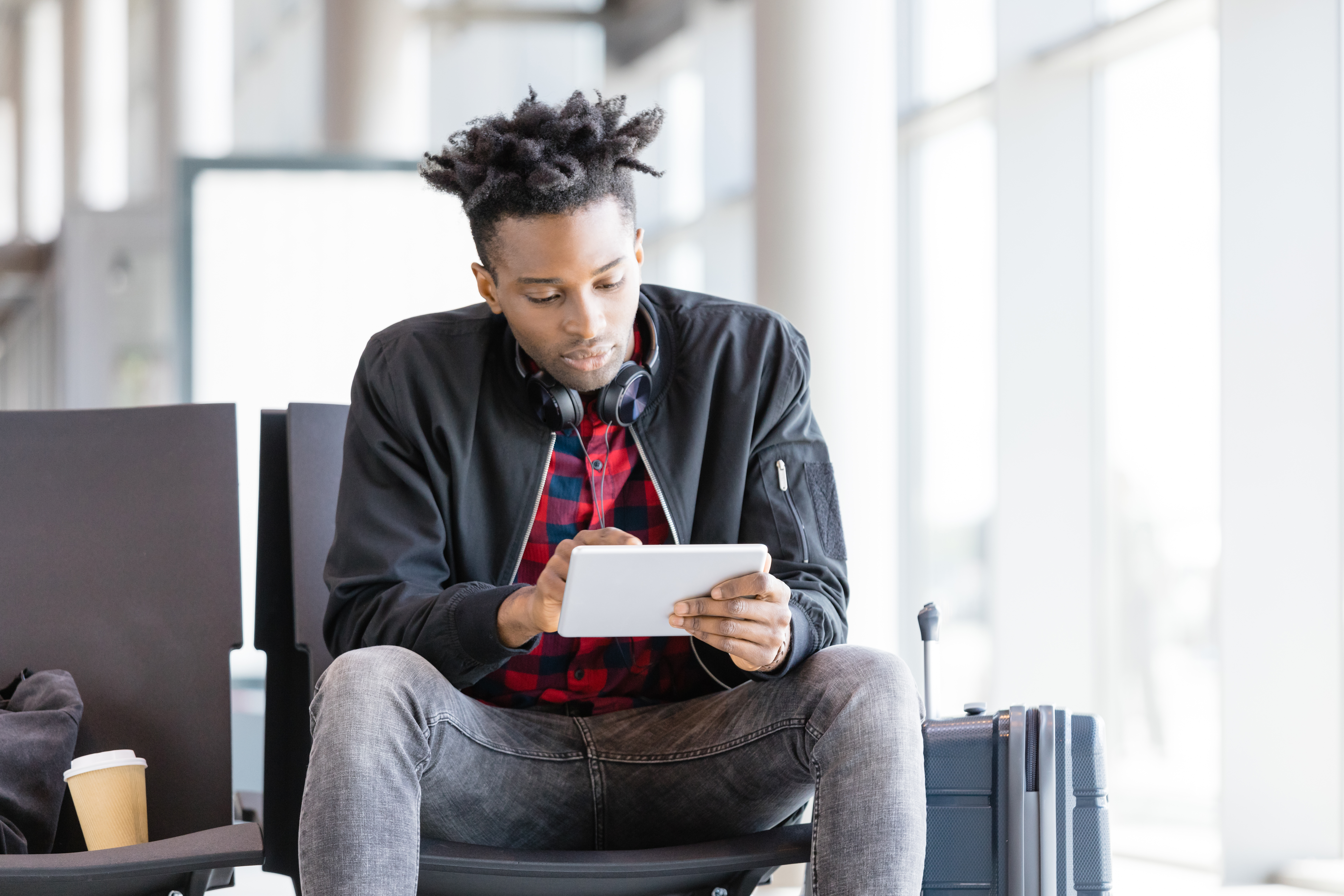 Young african using digital tablet in airport lounge