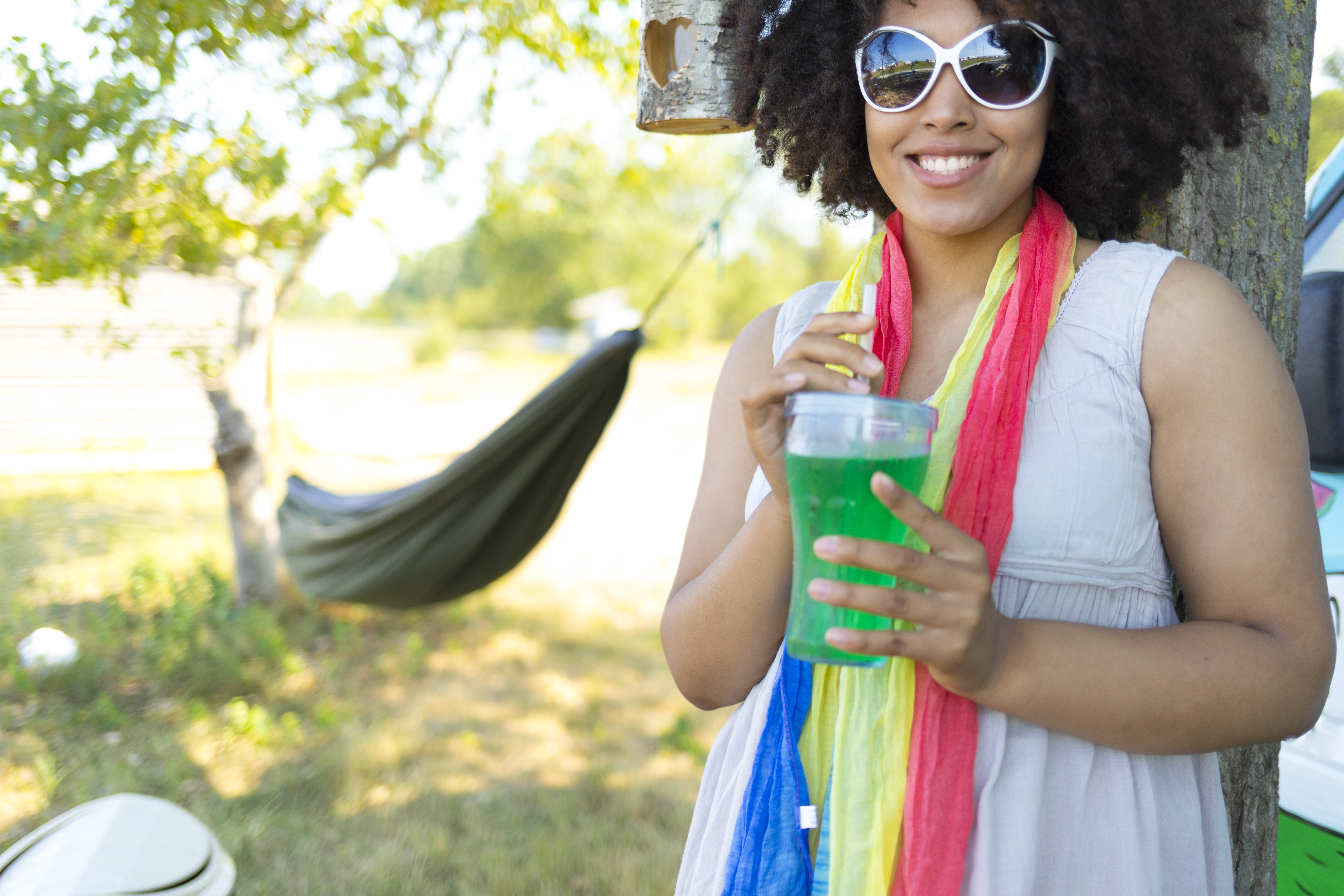 Smiling woman drinking green cocktail
