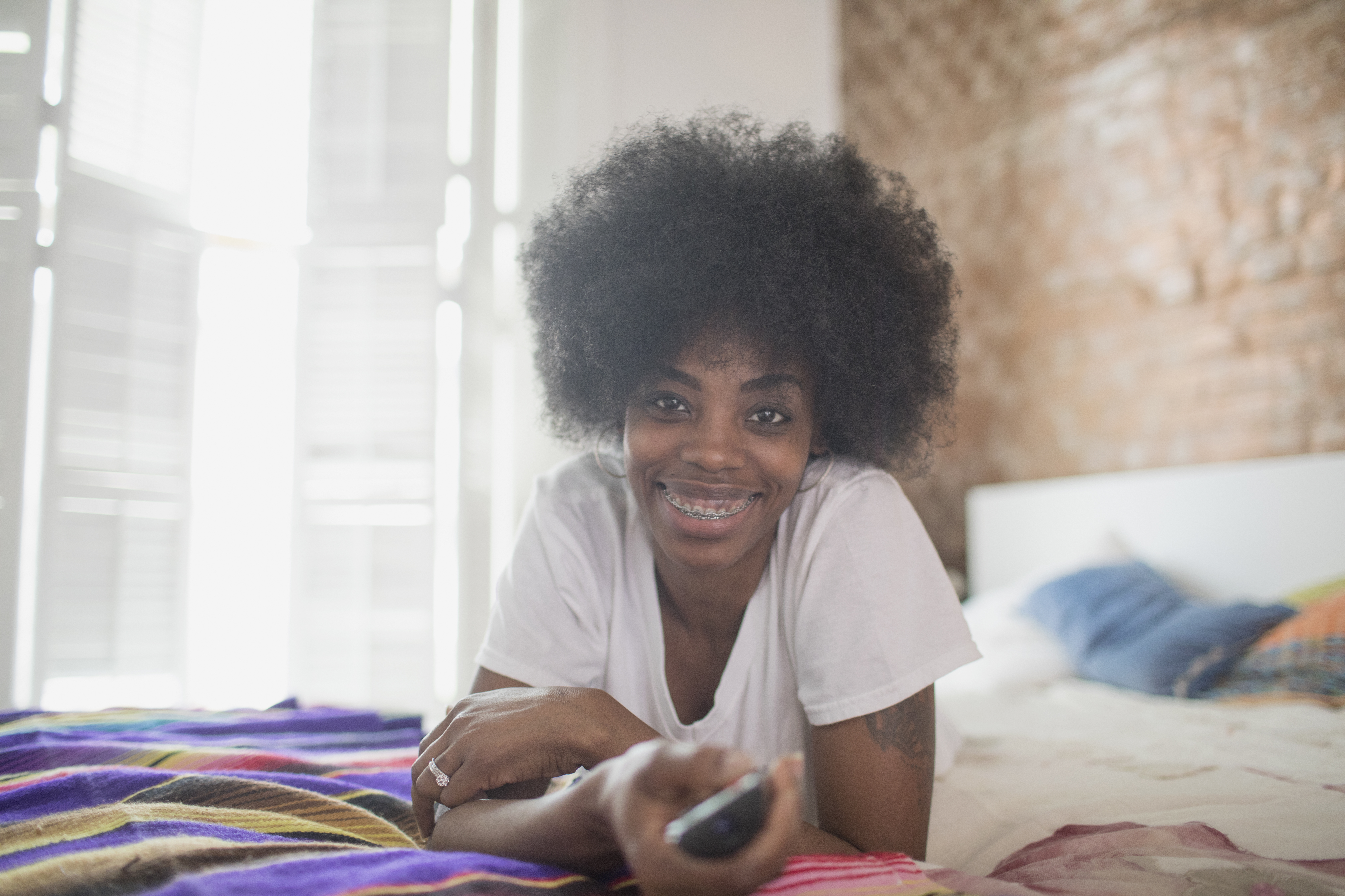 Woman watching television on her bed