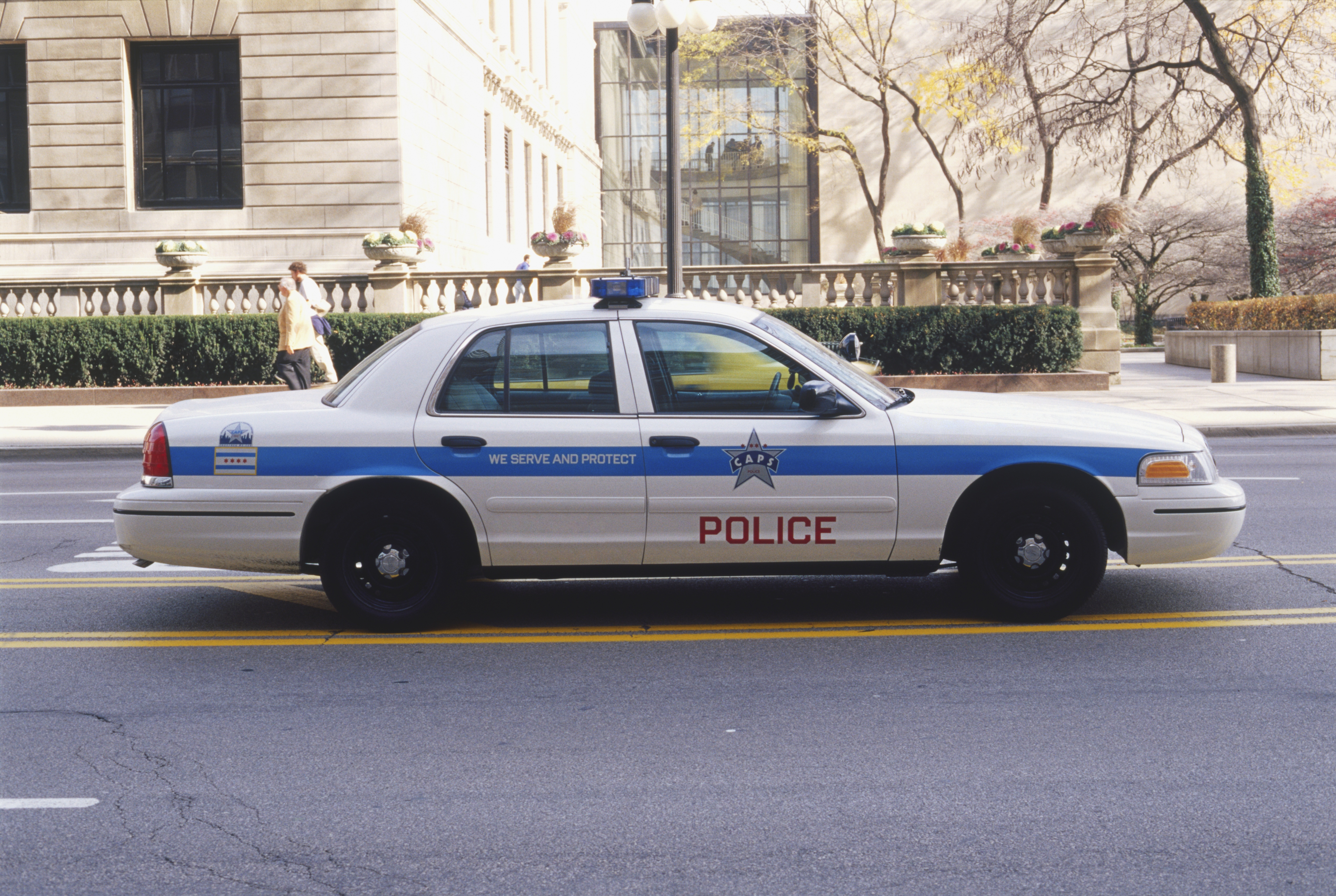 USA, Illinois, Chicago, police car driving along street, side view.
