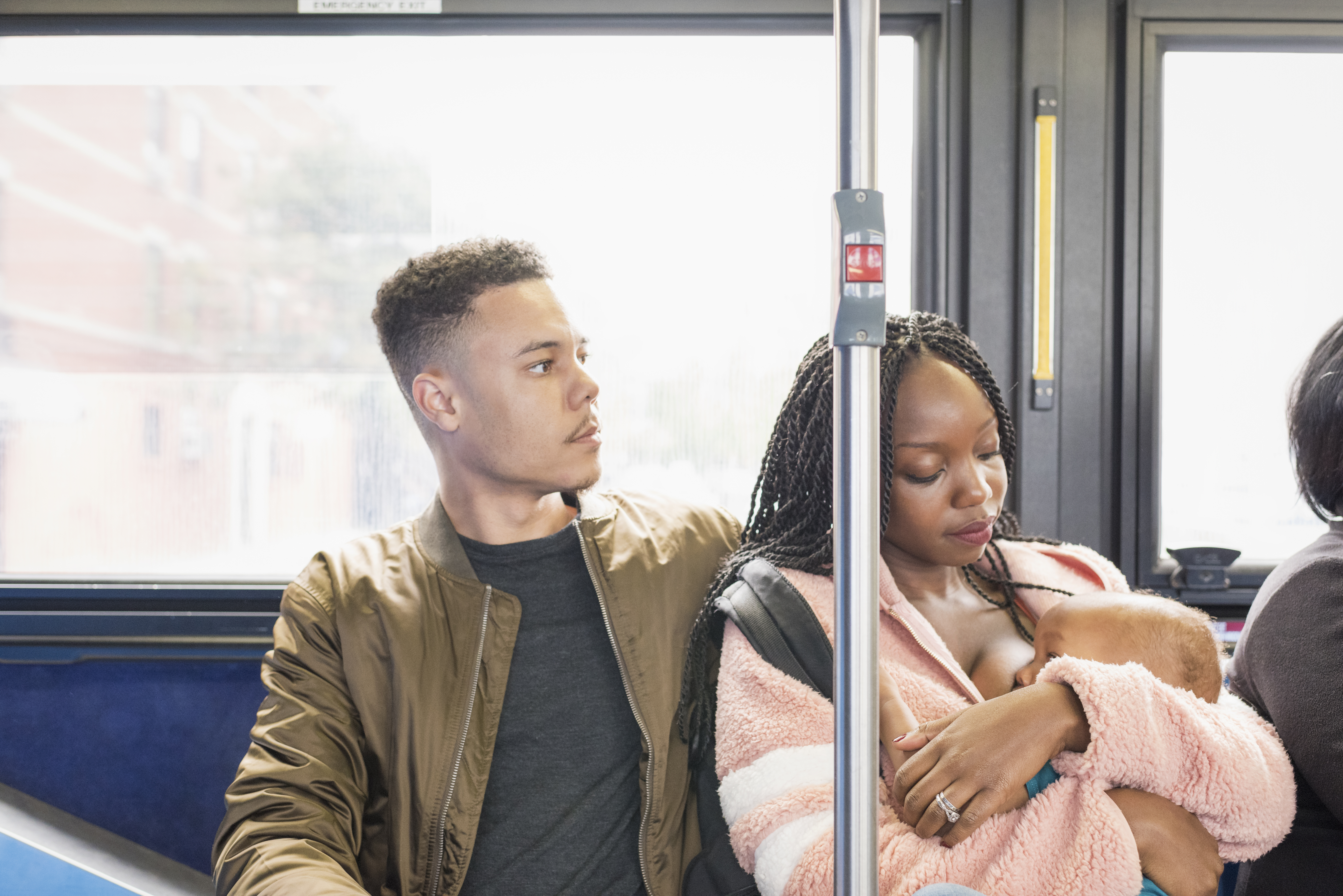 Young mother father and infant riding city bus