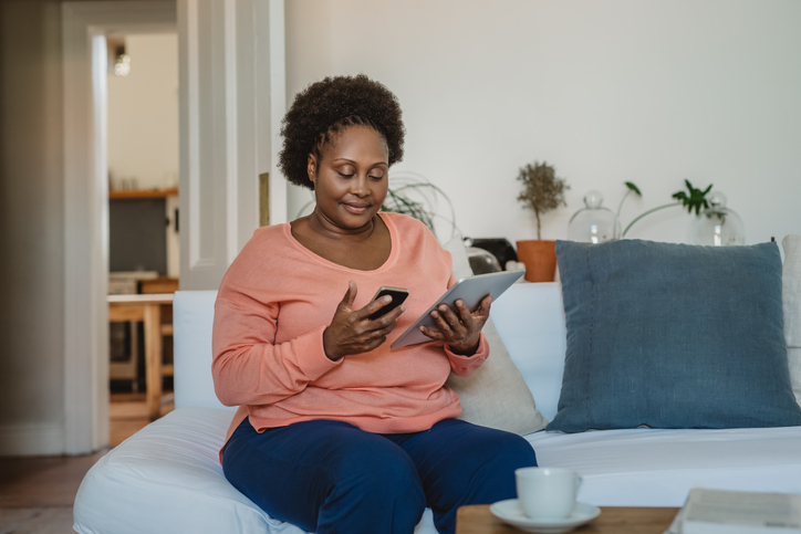 Smiling African American woman browsing online with a digital tablet