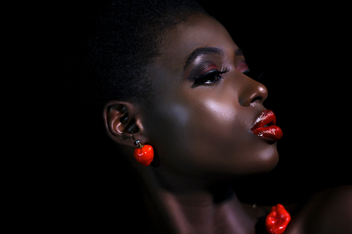 Close-Up Of Young Woman Looking Away Against Black Background