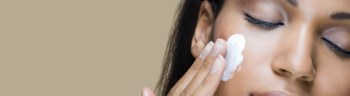 A woman rubbing moisturizer into her skin