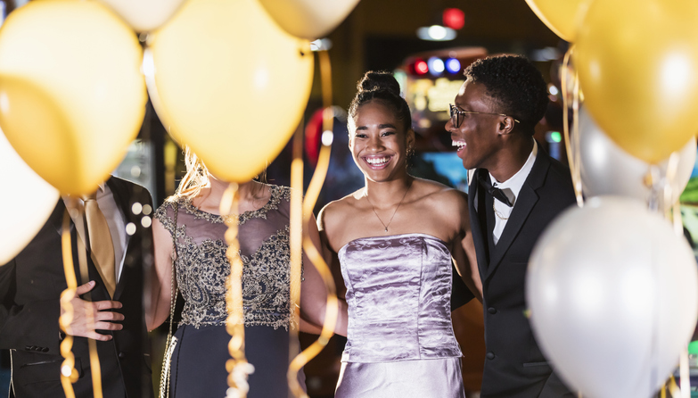 Teenage couple with friends having fun at prom