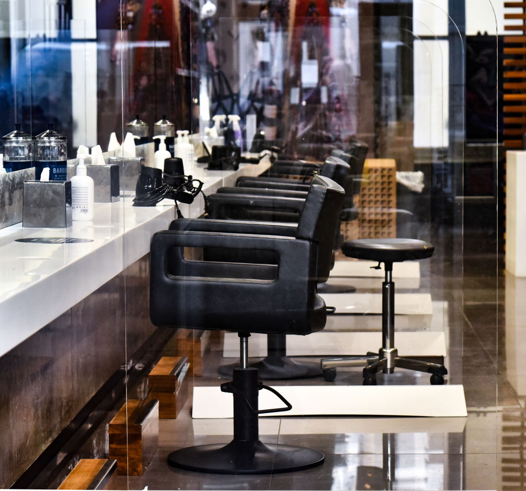 Perspex screens separating chairs in a hair dresser's salon...