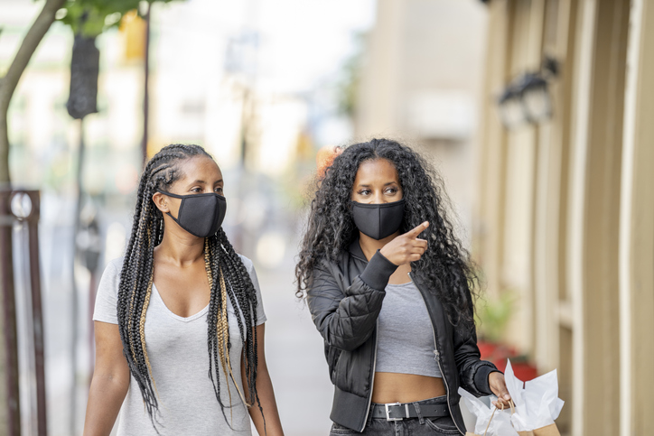 African American sisters shopping downtown wearing masks
