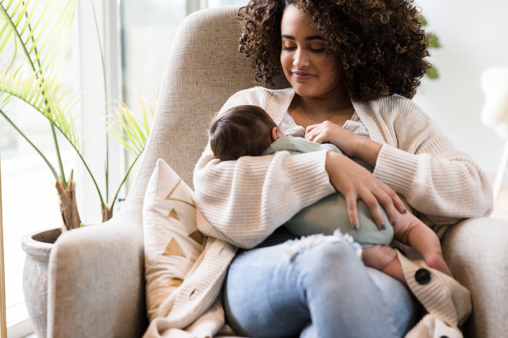 Happy mom breastfeeds her infant son