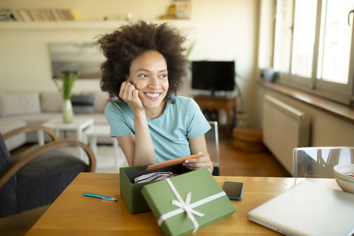 Happy African American woman opening a present