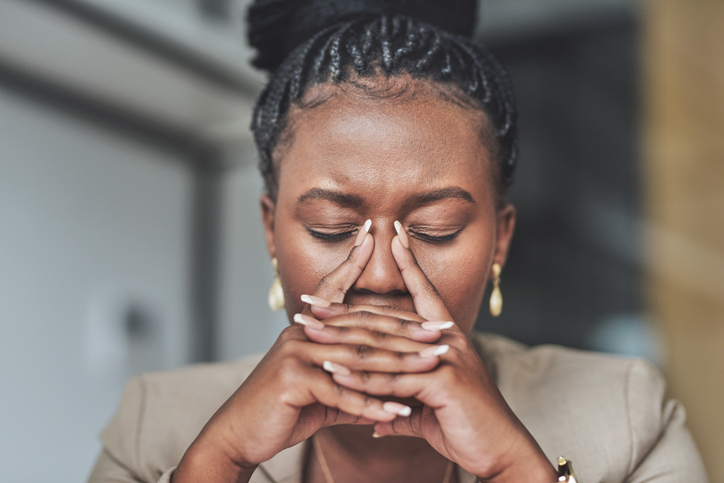 Shot of a young businesswoman stressed woman sitting at her desk in her office