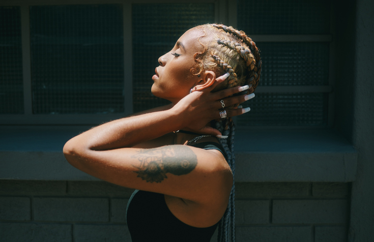 Cropped shot of an attractive young woman standing alone and posing outside during the day