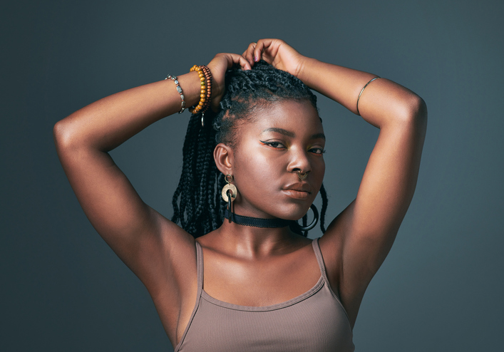 Studio shot of a trendy young woman posing against a grey background