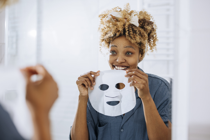Beauty Routine: Beautiful Woman Holding and Putting a Face Mask