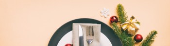 Christmas table place setting with christmas decor and plates, kine, fork and spoon. Christmas holiday background. Top view