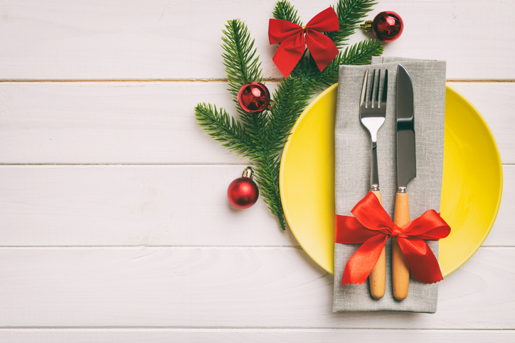 Christmas table place setting with christmas decor and plates, kine, fork and spoon. Christmas holiday background. Top view with copy space