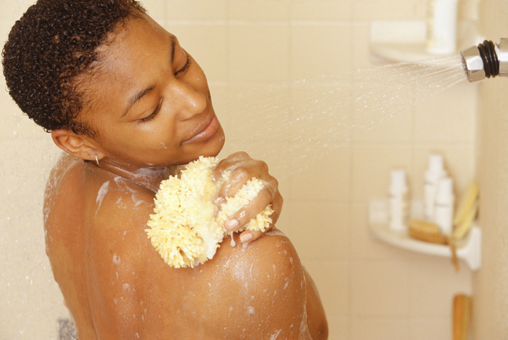 Woman washing using sponge in shower