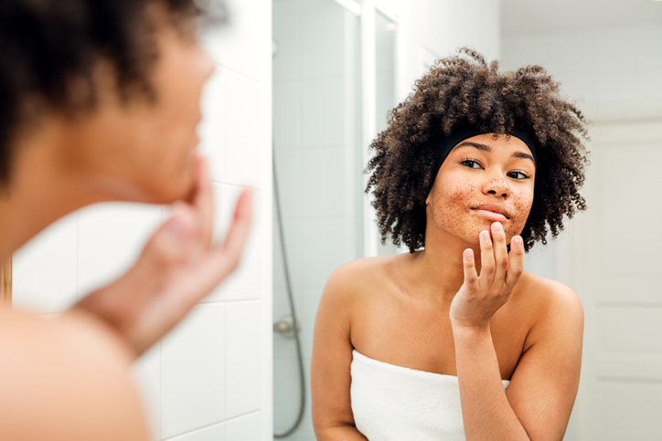 Beautiful girl with cosmetic scrub on her face - beauty products