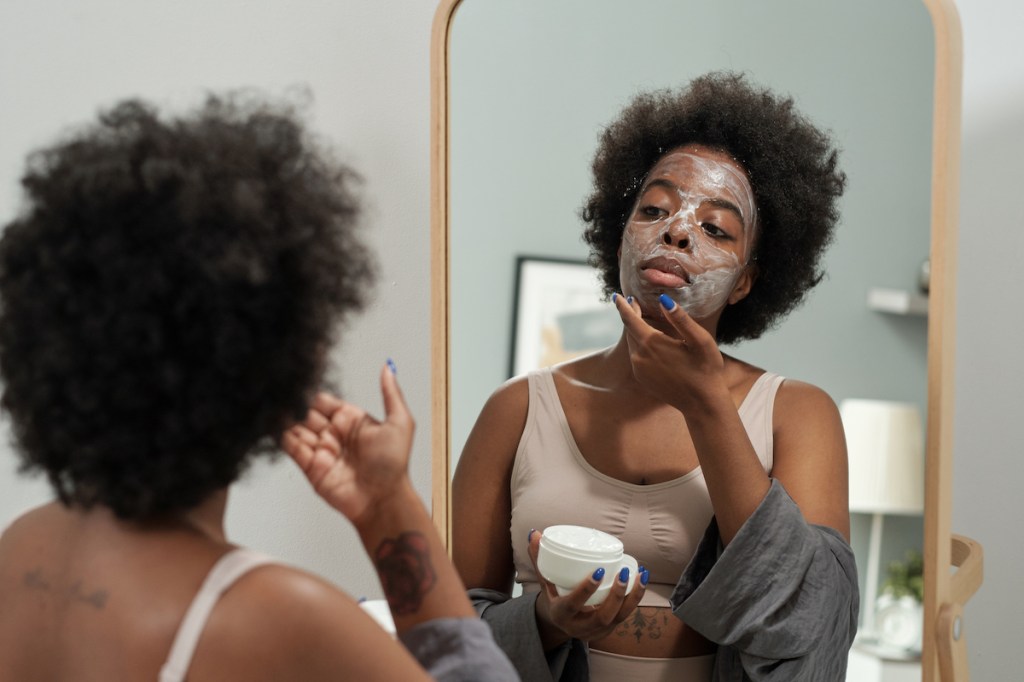 A woman applying face cream