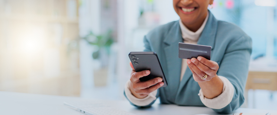 Credit card, payment and phone with hands of woman in office for fintech, online shopping an investment. Ecommerce, savings and banking app with closeup of employee for business, website and finance - loud budgeting
