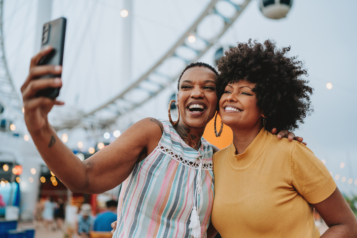 Two friends taking selfie with smartphone