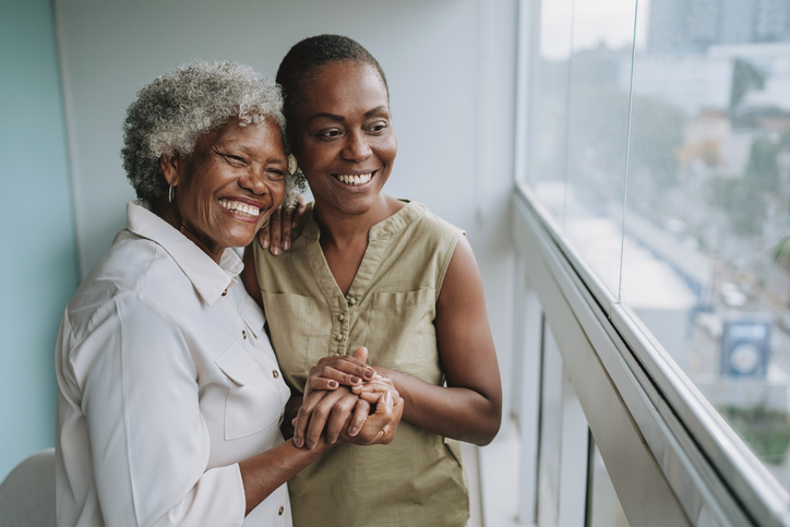 Mother and adult daughter looking at the view from the doctor's office