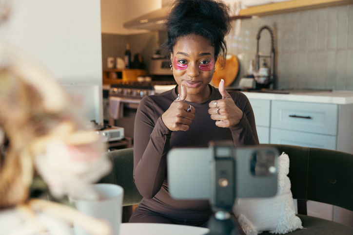 Influencer talking about beauty treatment with cosmetic patches on her eyes