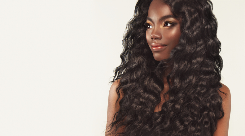 Portrait of black woman with long black wavy hair and dressed in elegant makeup. Beauty hairstyle and fashion.